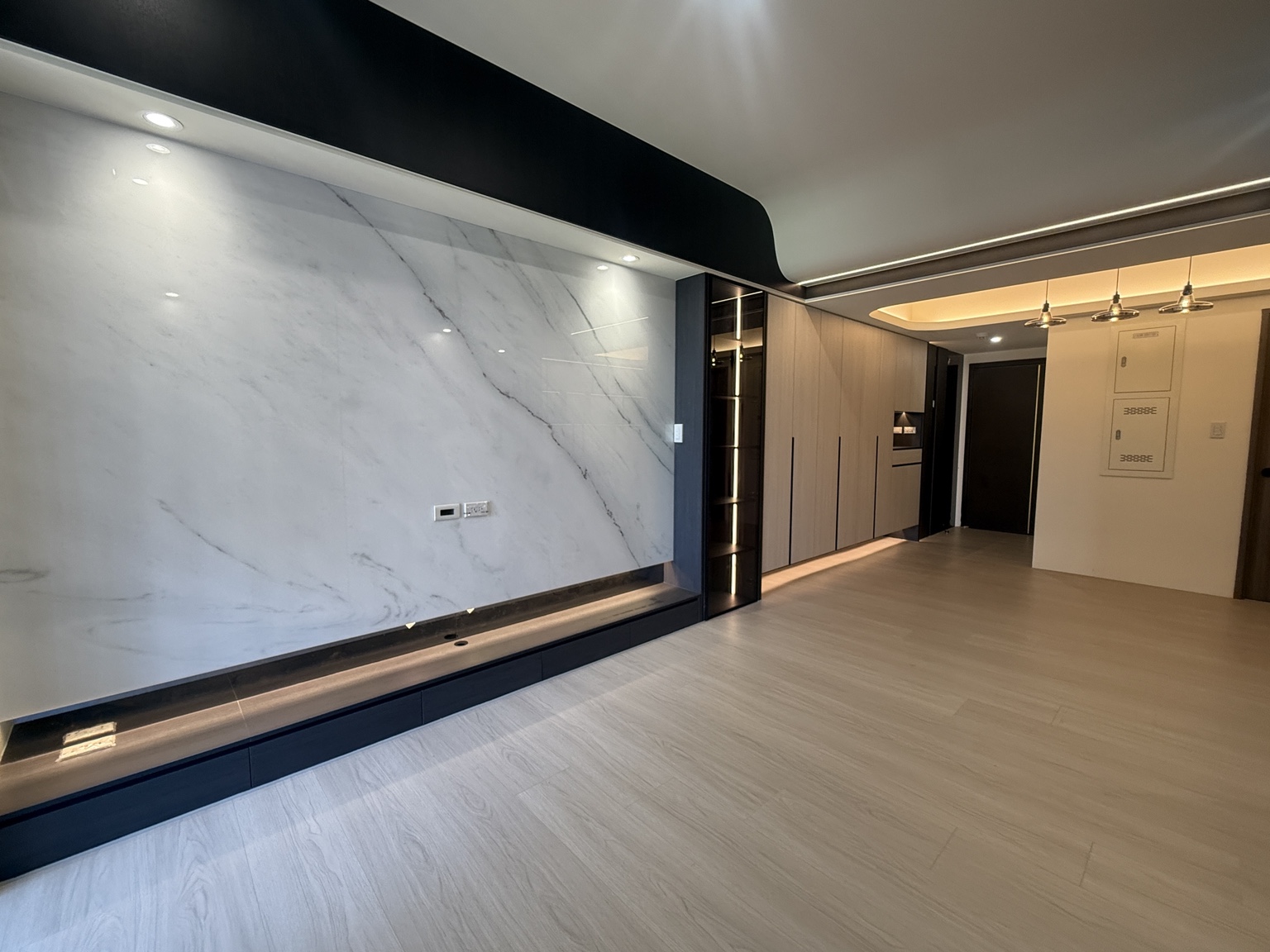水滴地板客廳完工作品，淺色木紋地板搭配石紋電視牆與深色櫃體